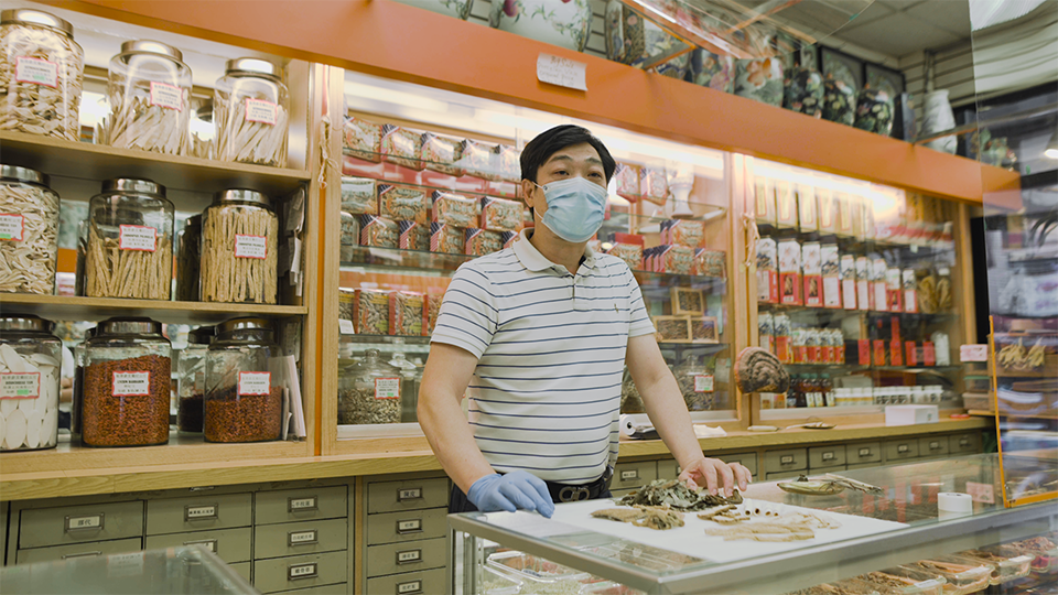 Mr. Zhou behind the counter at Ewa Trading